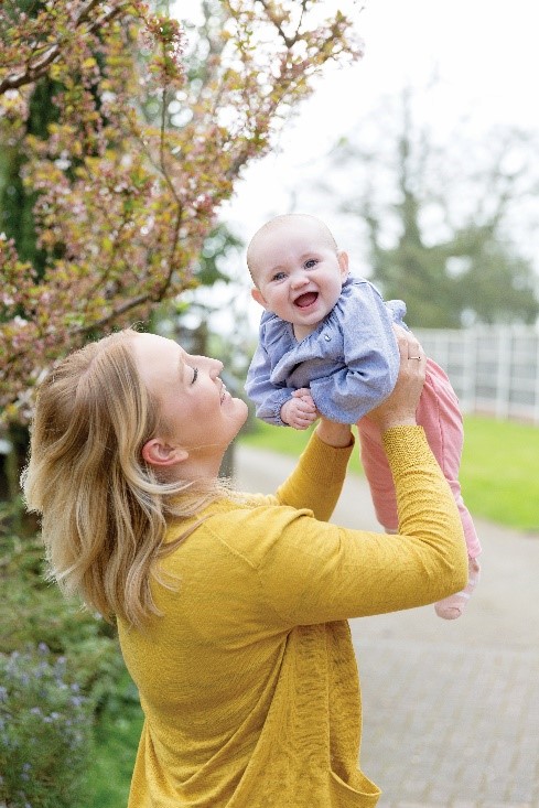 Mother holding smiling baby in the air